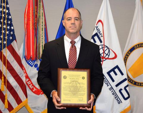 Man holding charter in front of flags.