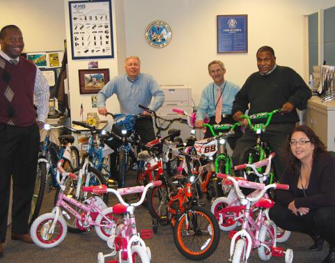 People stand around 15 bicycles collected for Toys for Tots